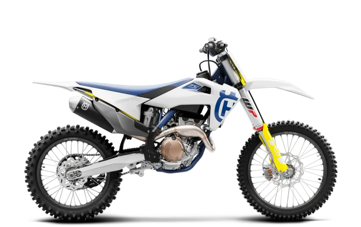 Biały motocykl Husqvarna FC 250 z niebieskim siedzeniem i żółtymi akcentami, gotowy do jazdy po torze.