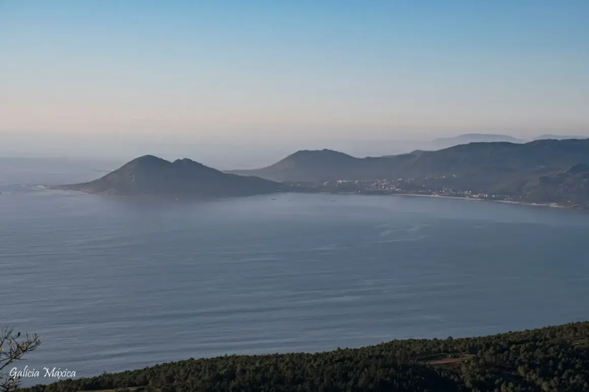 Vista panorámica de la costa gallega con el monte Enxa destacando sobre el mar azul.
