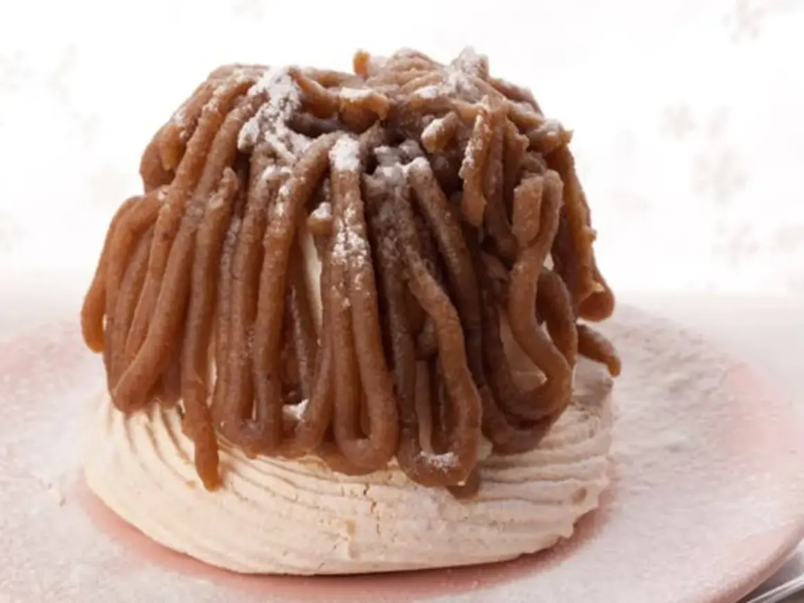 Delicioso mont blanc dulce, un postre de merengue cubierto con crema de castañas y espolvoreado con azúcar glas.