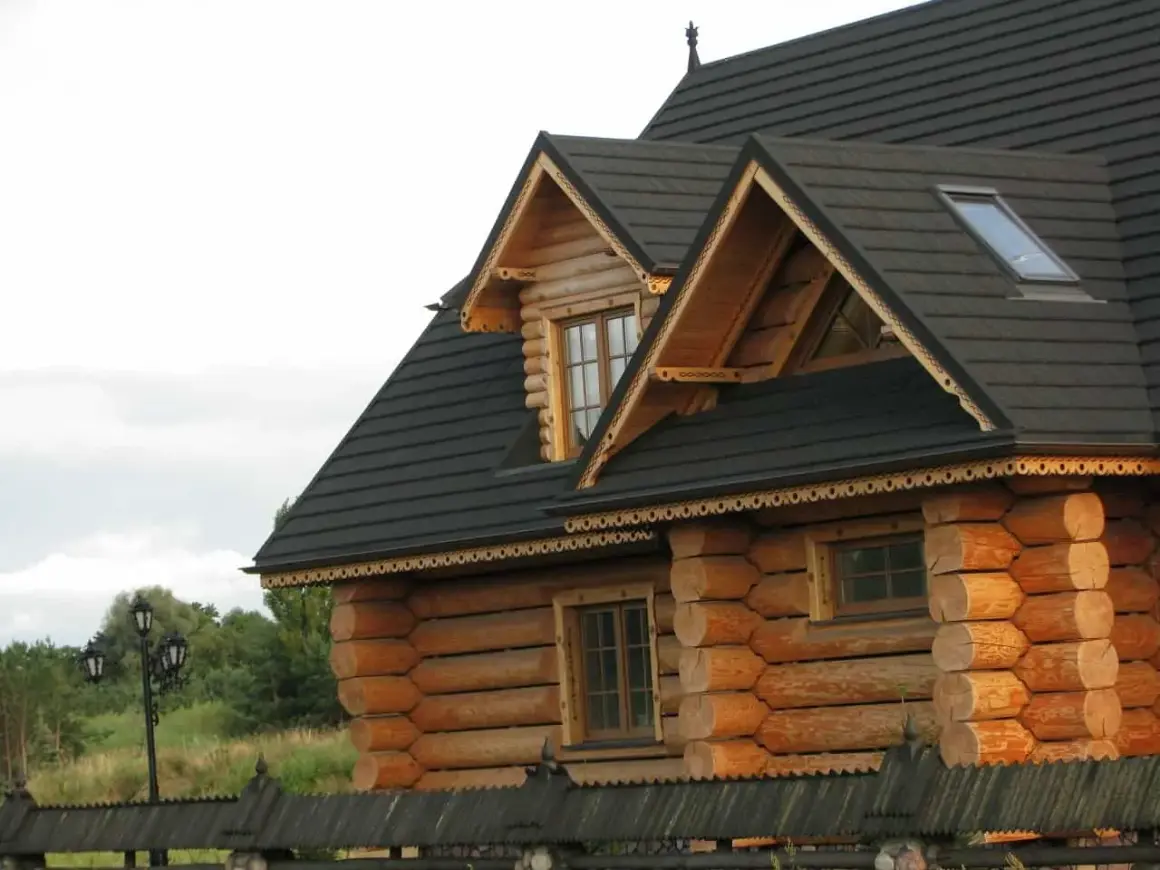 Piękny drewniany dom z bali, z ozdobnym okapem. Zastanawiasz się, ile kosztuje przeniesienie domu drewnianego?