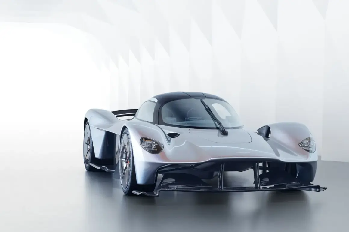 Srebrny Aston Martin Valkyrie, supersamochód o futurystycznym designie, prezentuje swoje aerodynamiczne linie w minimalistycznym wnętrzu.