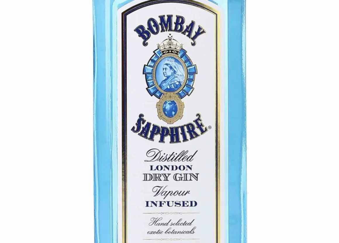 Niebieska butelka z etykietą Bombay Sapphire, na której widnieje portret królowej i napis "Distilled London Dry Gin".