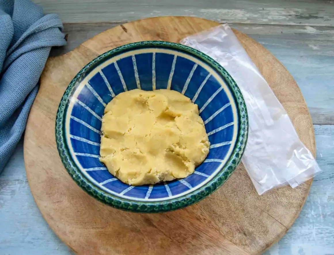 Frischer quiche teig in einer blauen Schüssel, bereit für die Zubereitung einer herzhaften Quiche.