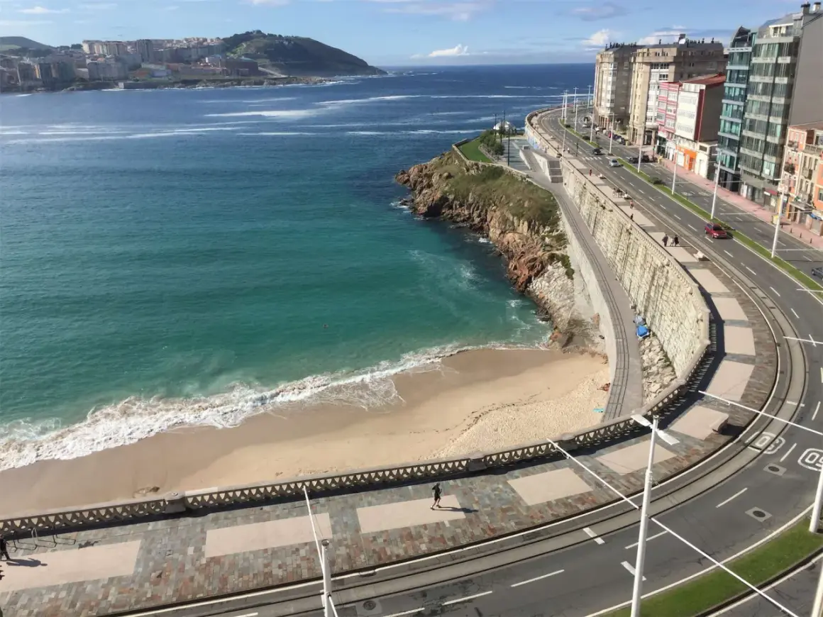 Una de las 10 mejores playas de A Coruña, con arena dorada, mar turquesa y un paseo marítimo con edificios modernos.