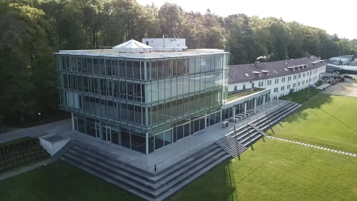 Moderner Glasbau der Hochschule Friedrichshafen mit angrenzendem Campus und Wald.