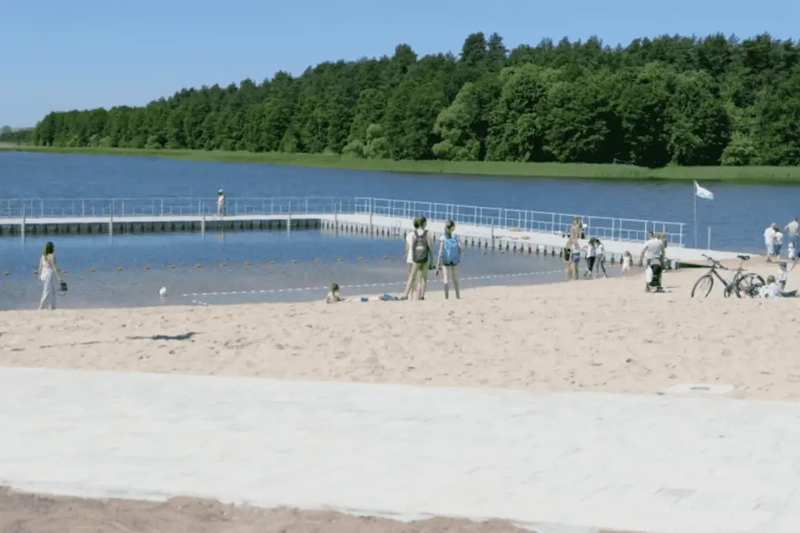 Słoneczne plaże na Mazurach przyciągają ludzi. Dzieci bawią się na piasku, a dorośli spacerują po pomoście.