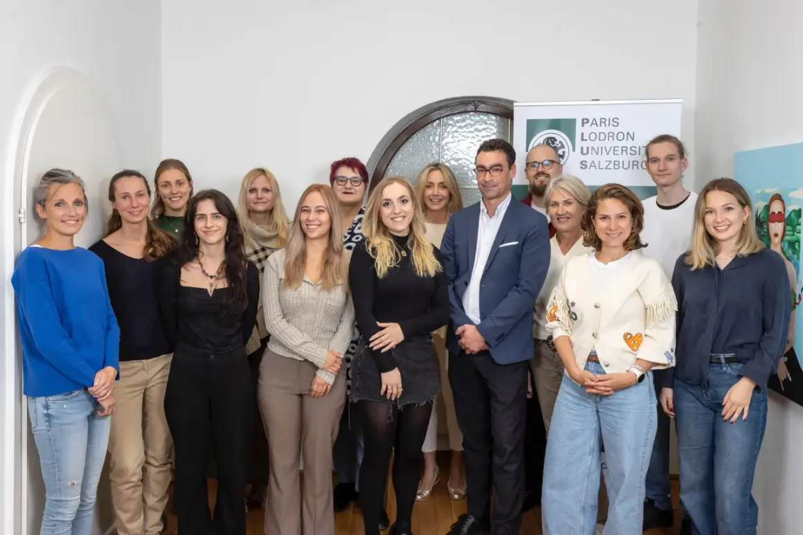 Gruppe von Studierenden und Dozierenden der Paris Lodron Universität Salzburg, Fachbereich Psychologie, posiert für ein Gruppenfoto.
