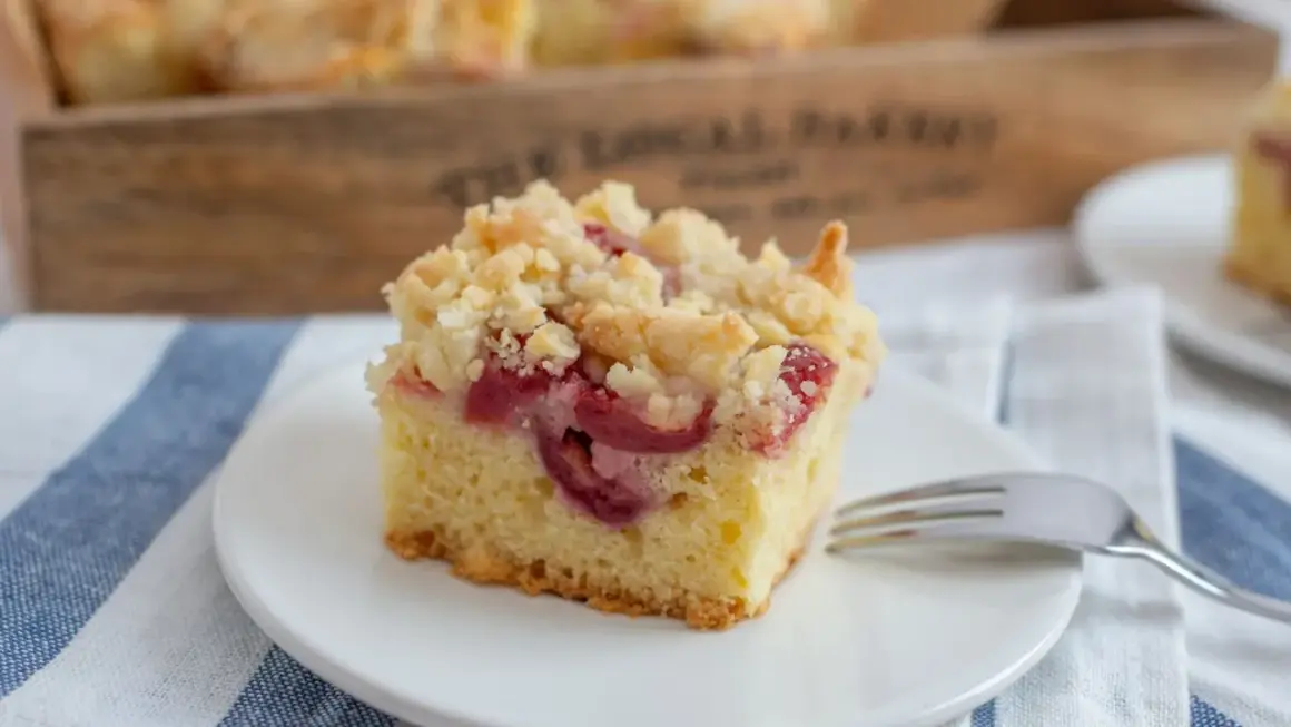 Ein Stück Kirsch-Streuselkuchen auf einem Teller, bereit zum Genießen. Dieses Streuselkuchen Rezept ist ein Klassiker.