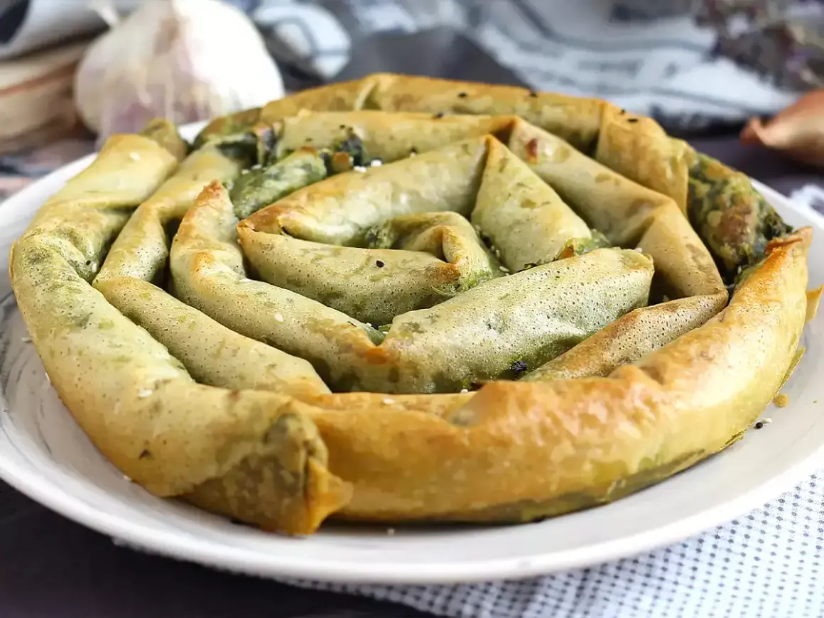 En gyllene, spiralformad burek med spenatfyllning. Ett läckert burek recept att prova!