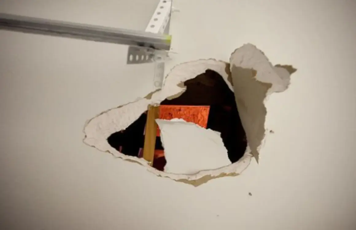 Un **buco nel muro troppo grande** rivela una struttura arancione e un montante di legno.