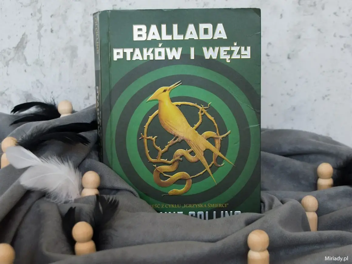 Okładka "Ballady ptaków i węży" z cyklu "Igrzyska Śmierci". Żółty ptak i wąż na tle zielonych kręgów.