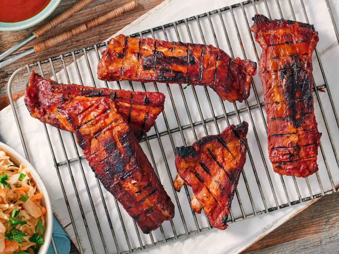 Saftige Rippchen mit glasiertem, karamellisiertem Fleisch auf einem Grillrost. Perfekt für eine rippchen marinade einfach.