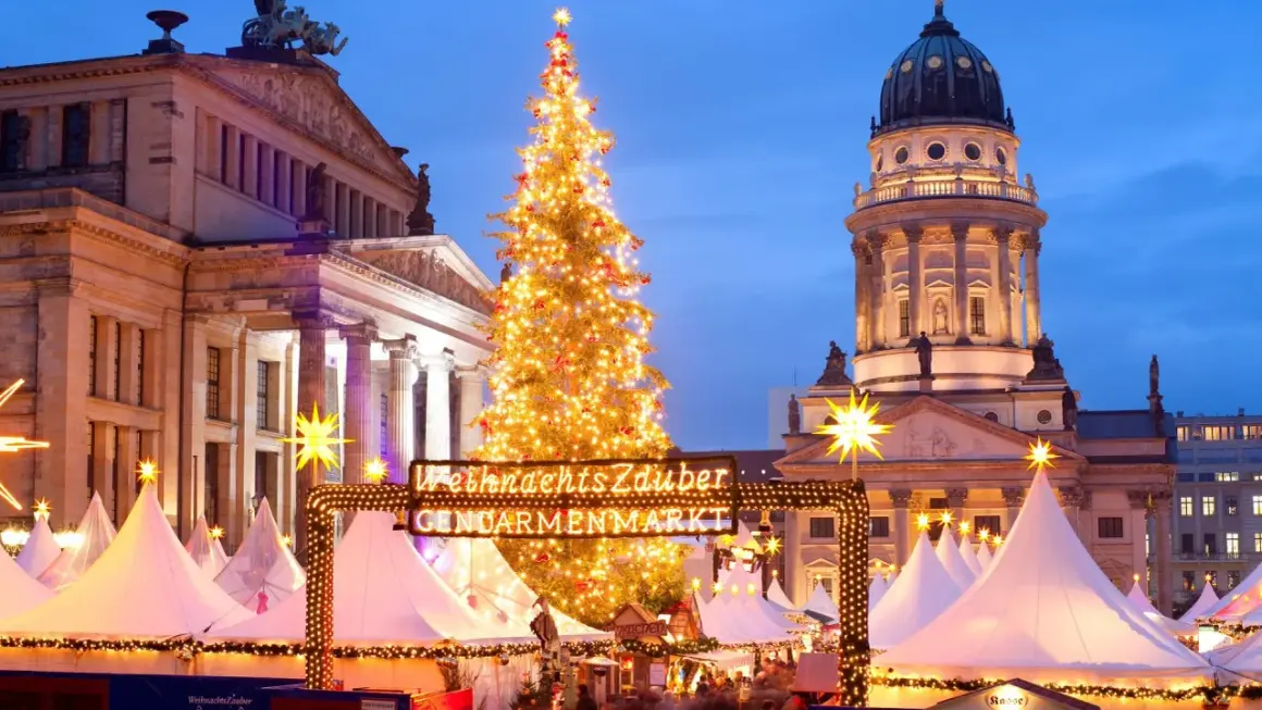Jarmark Gendarmenmarkt w Berlinie, jeden z najpiękniejszych jarmarków bożonarodzeniowych w Europie, z choinką i kopułą kościoła w tle.