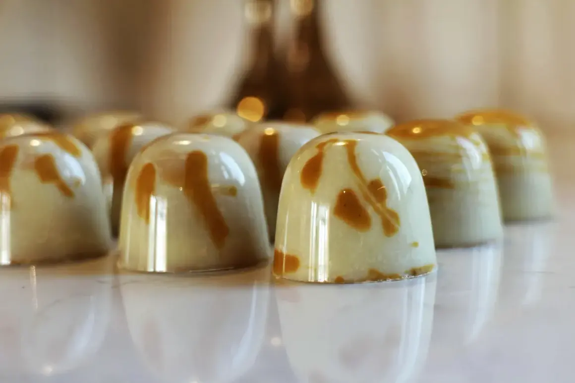 En rad blanka praliner med marmorerad ganache. Perfekt för ett ganache recept till praliner.