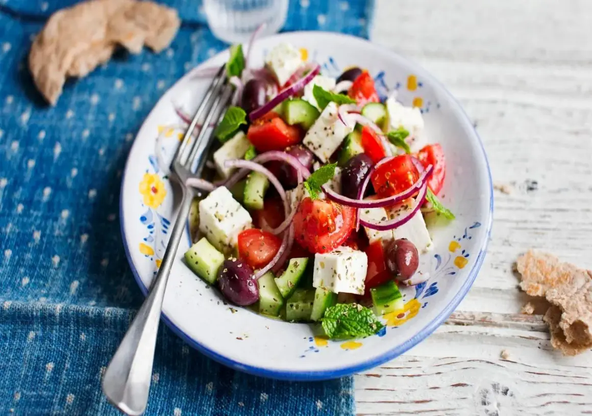 En fräsch fetaost sallad med tomater, gurka, rödlök och oliver, perfekt för en lätt lunch.