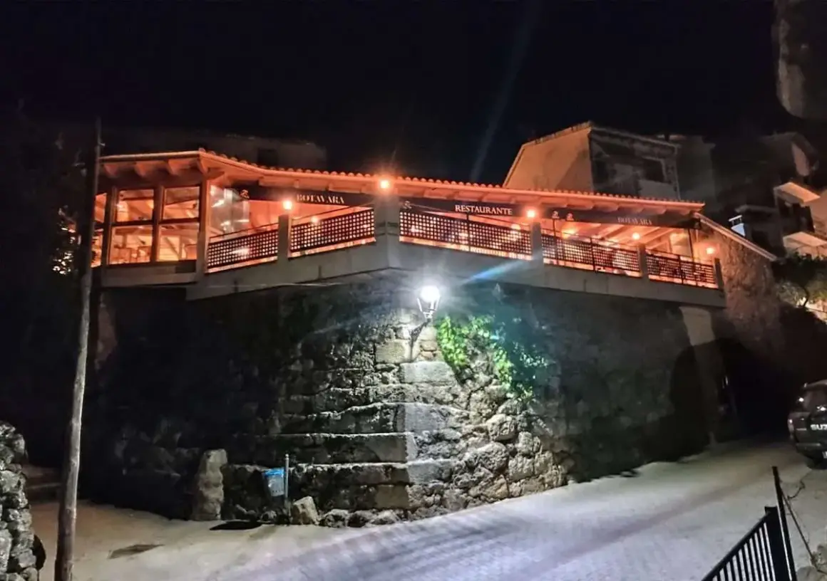 Restaurante Botavara San Jose, iluminado por la noche, con escaleras de piedra y una vista acogedora.