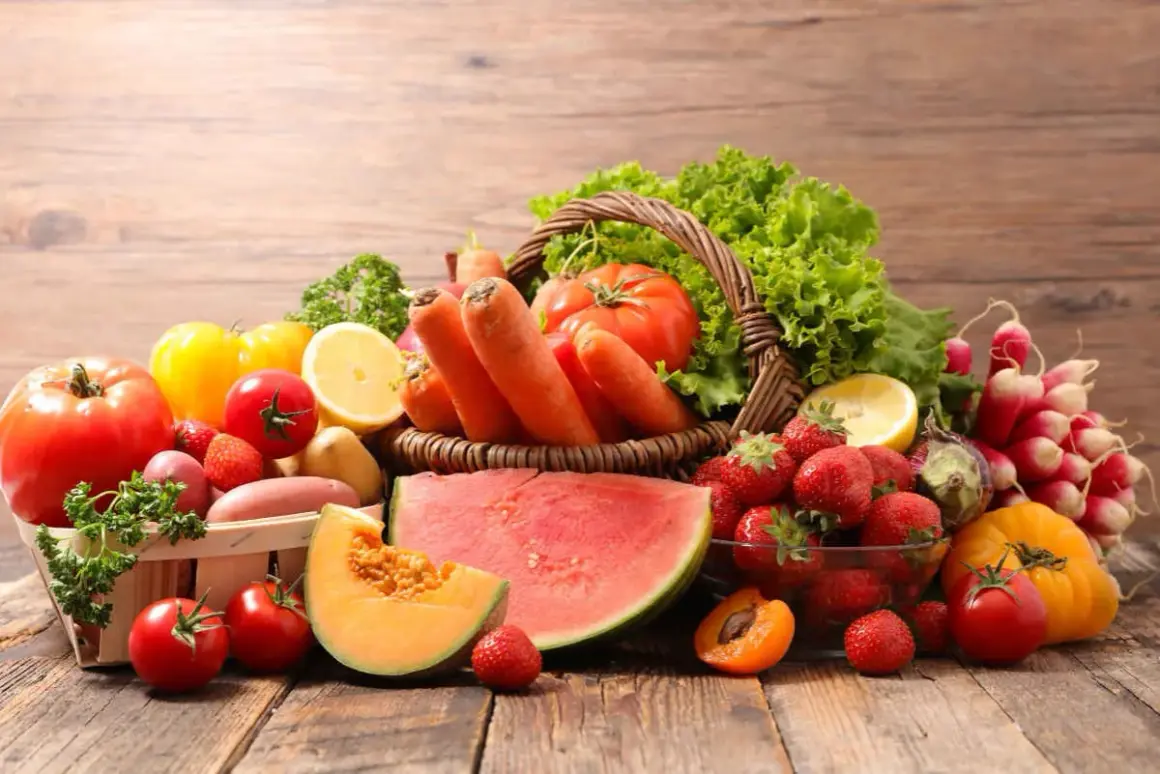 Un cesto traboccante di frutta di stagione giugno: fragole, melone, albicocche, anguria, carote, pomodori, lattuga e limone.