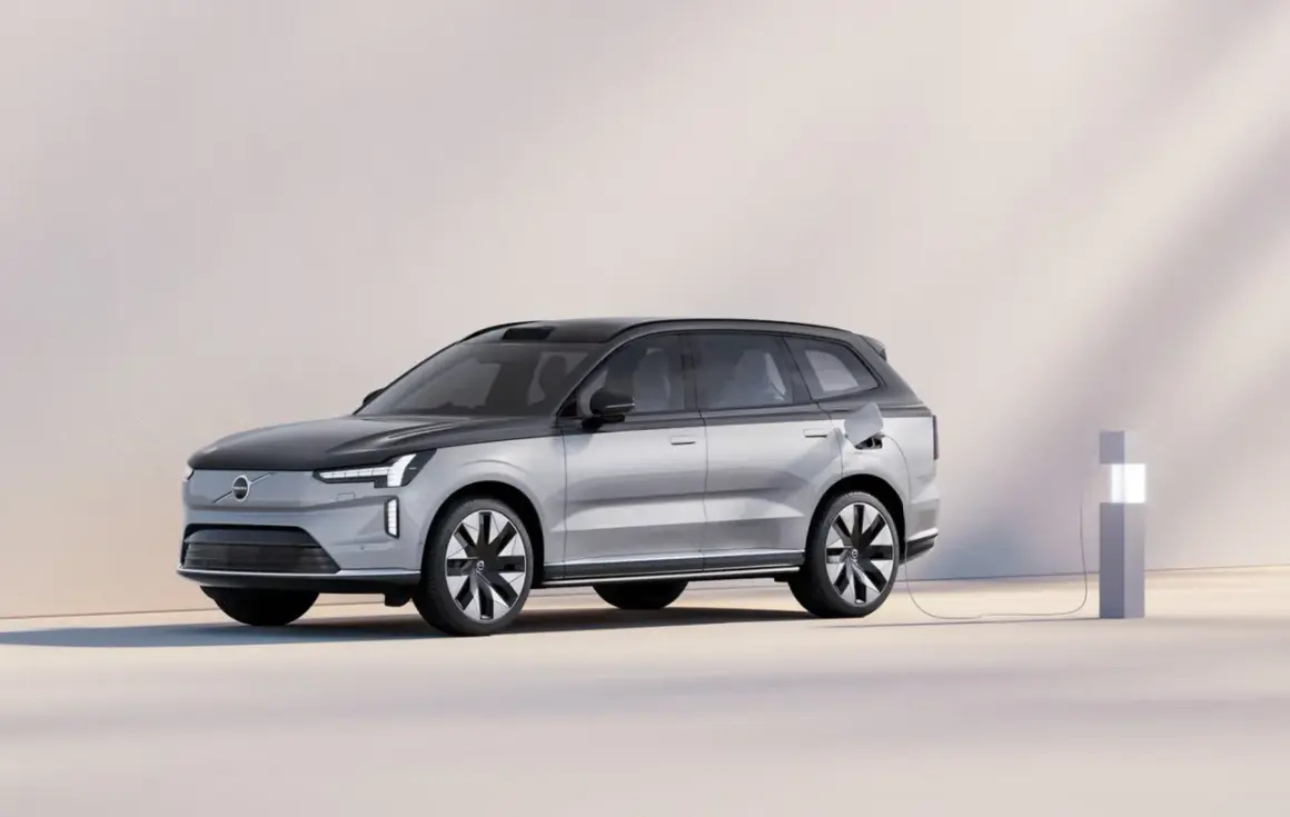 En silverfärgad elbil laddas vid en laddstation. Undrar du vad kostar en ny bil? Denna Volvo ser futuristisk ut.