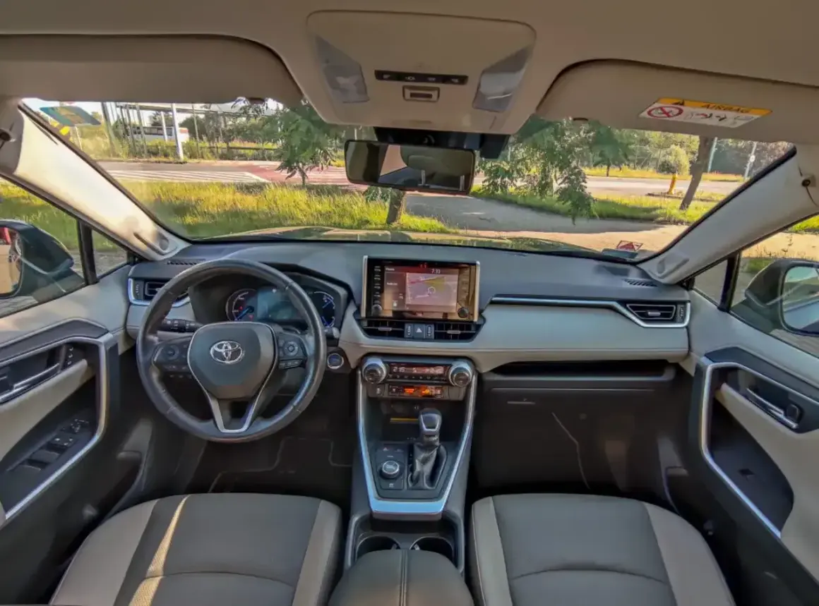 Wnętrze Toyoty RAV4. Kierownica, ekran nawigacji i panel klimatyzacji. Czy to hybryda czy benzyna?