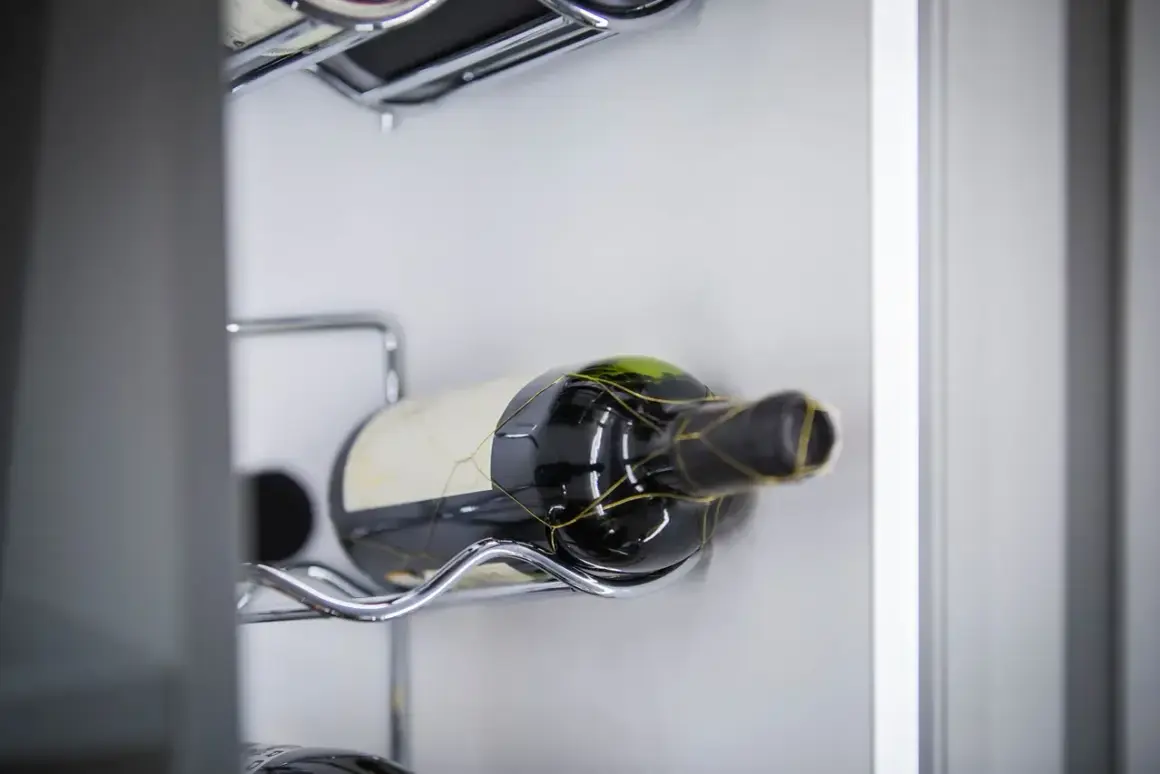 Eine Flasche Rotwein, die für die Lagerung von offenem Rotwein vorbereitet ist, liegt auf einem metallenen Gestell.