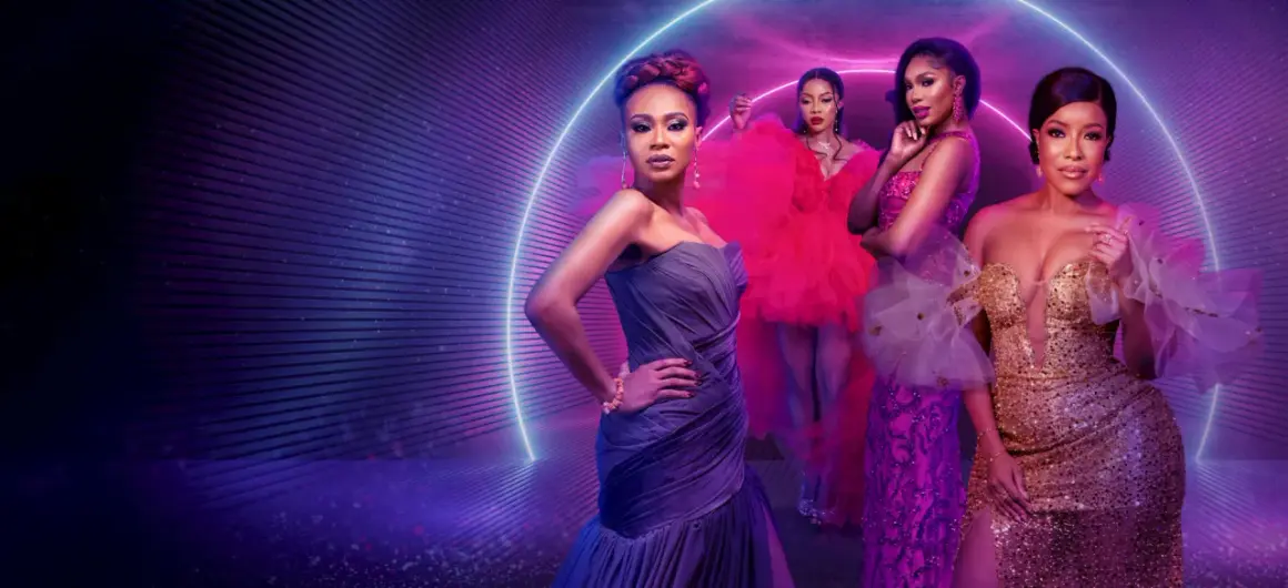 Fyra kvinnor i glittrande klänningar poserar framför en neonljusring. En scen som hämtad ur de mest glamorösa fashion movies.
