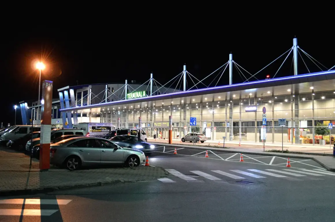 Nocne lotnisko, Terminal A, z autami i autokarami. Może to być podróż z Rzeszowa do Katowic.