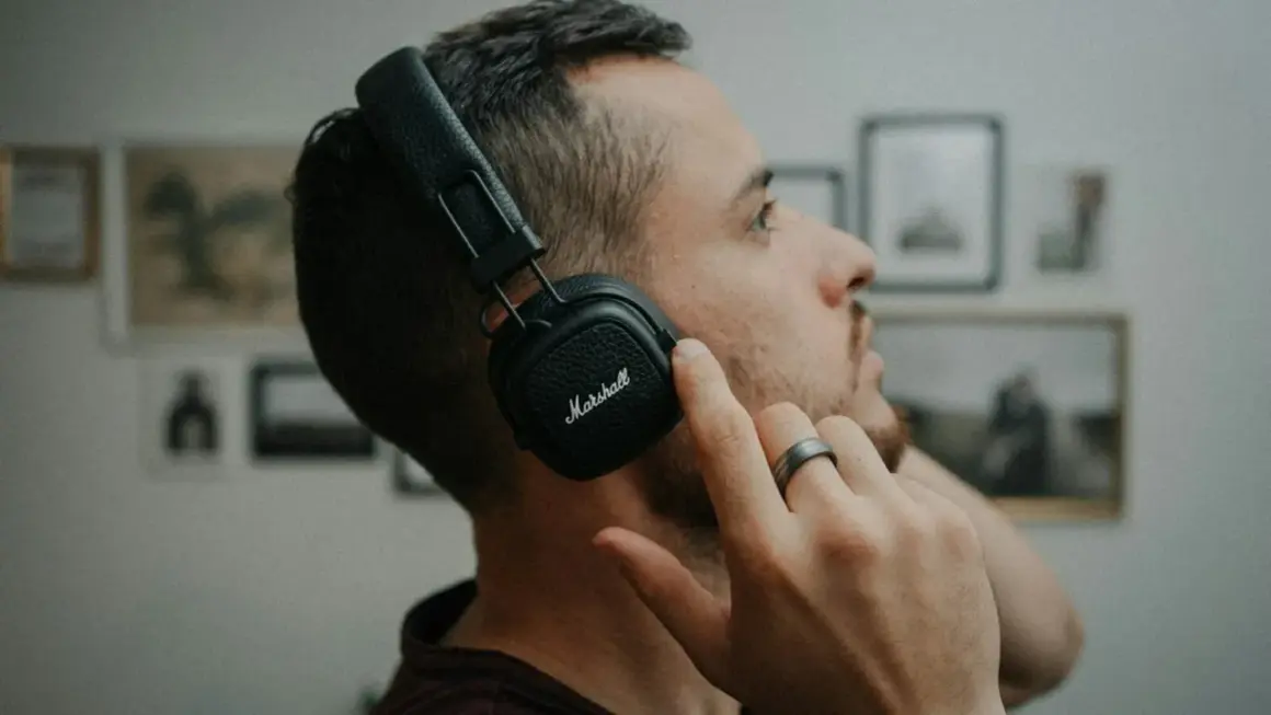 Mężczyzna w słuchawkach Marshall, skupiony na dźwiękach 432 hz.