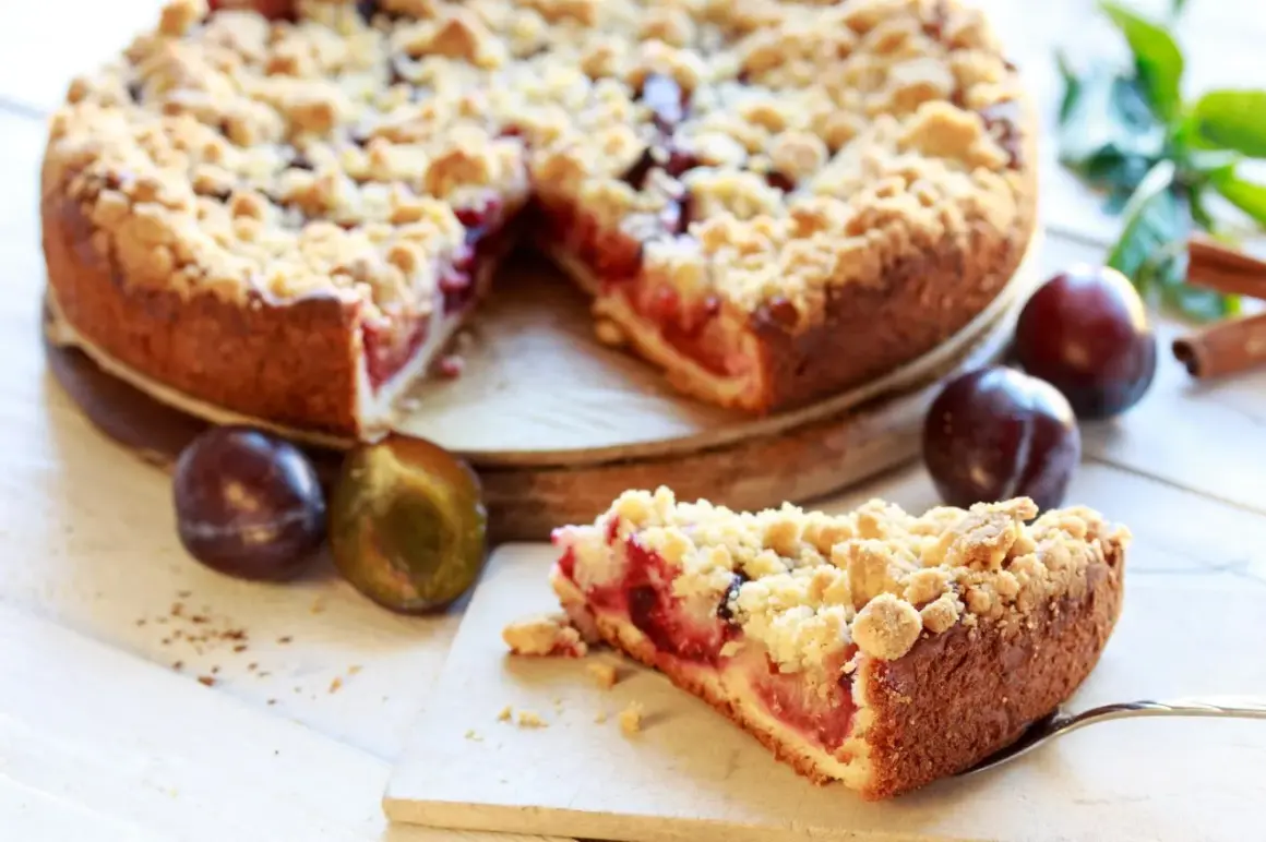 Saftiger Pflaumenkuchen mit Streuseln, perfekt für ein leckeres Pflaumenkuchen Rezept. Frische Pflaumen und Zimt daneben.
