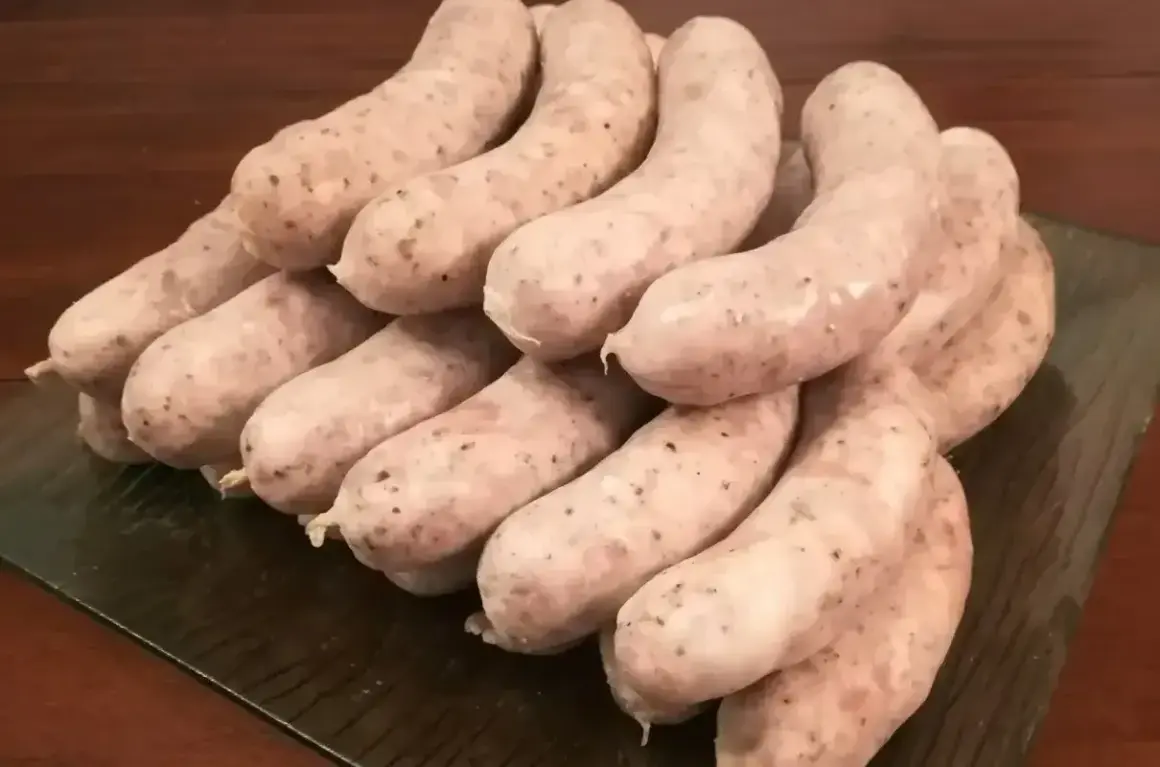 Stos białej kiełbasy, gotowej do przygotowania według przepisu na 5 kg. Idealna na wielkanocny stół.
