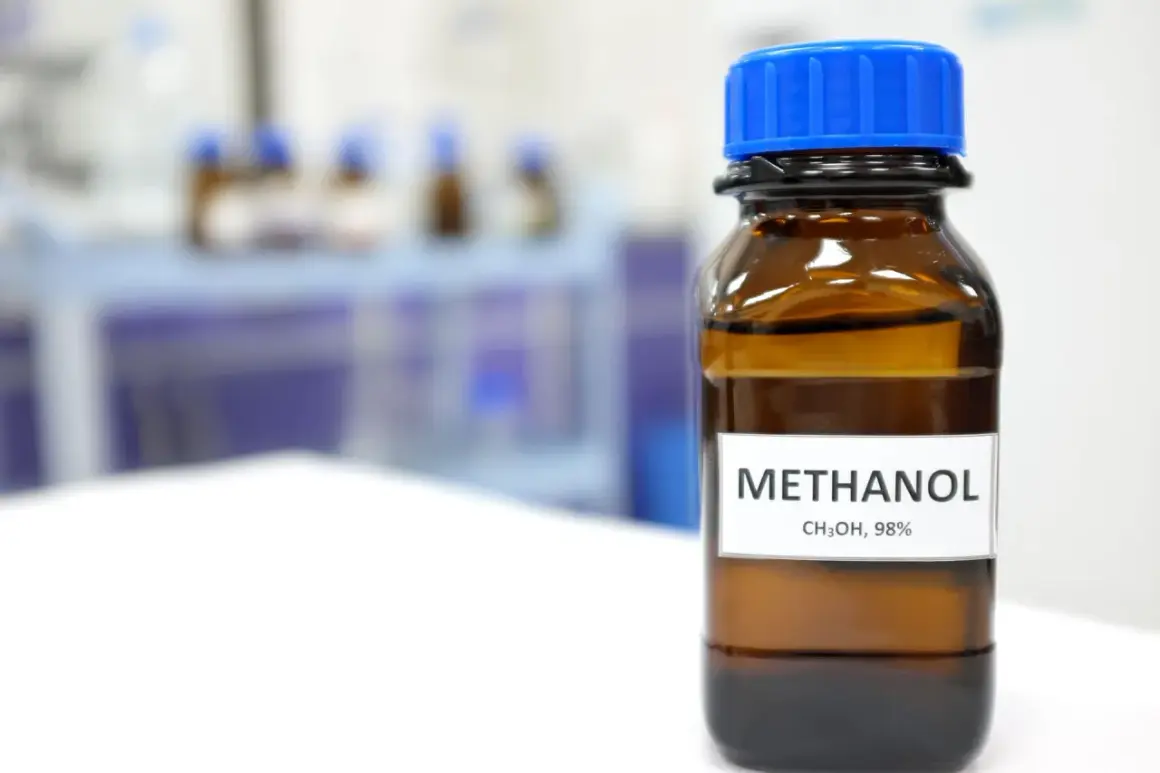 Brązowa butelka z niebieską zakrętką zawiera metanol, 98%. Substancja ta ma szerokie zastosowanie w przemyśle chemicznym.