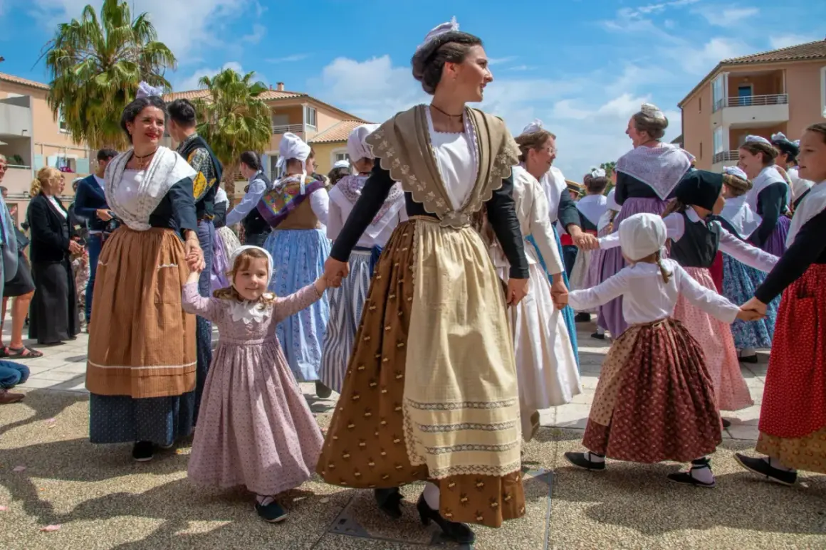 Un groupe danse en cercle, portant une tenue traditionnelle française homme et femme, avec des coiffes et des jupes colorées.