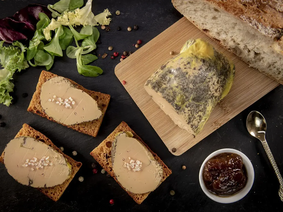 Tranches de foie gras sur toasts, accompagnées de pain frais, d'une compotée de fruits et d'une touche de cognac ou d'armagnac.