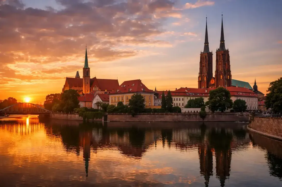 Zachód słońca nad Odrą we Wrocławiu, województwo. Katedra i zabytkowe budynki odbijają się w wodzie.