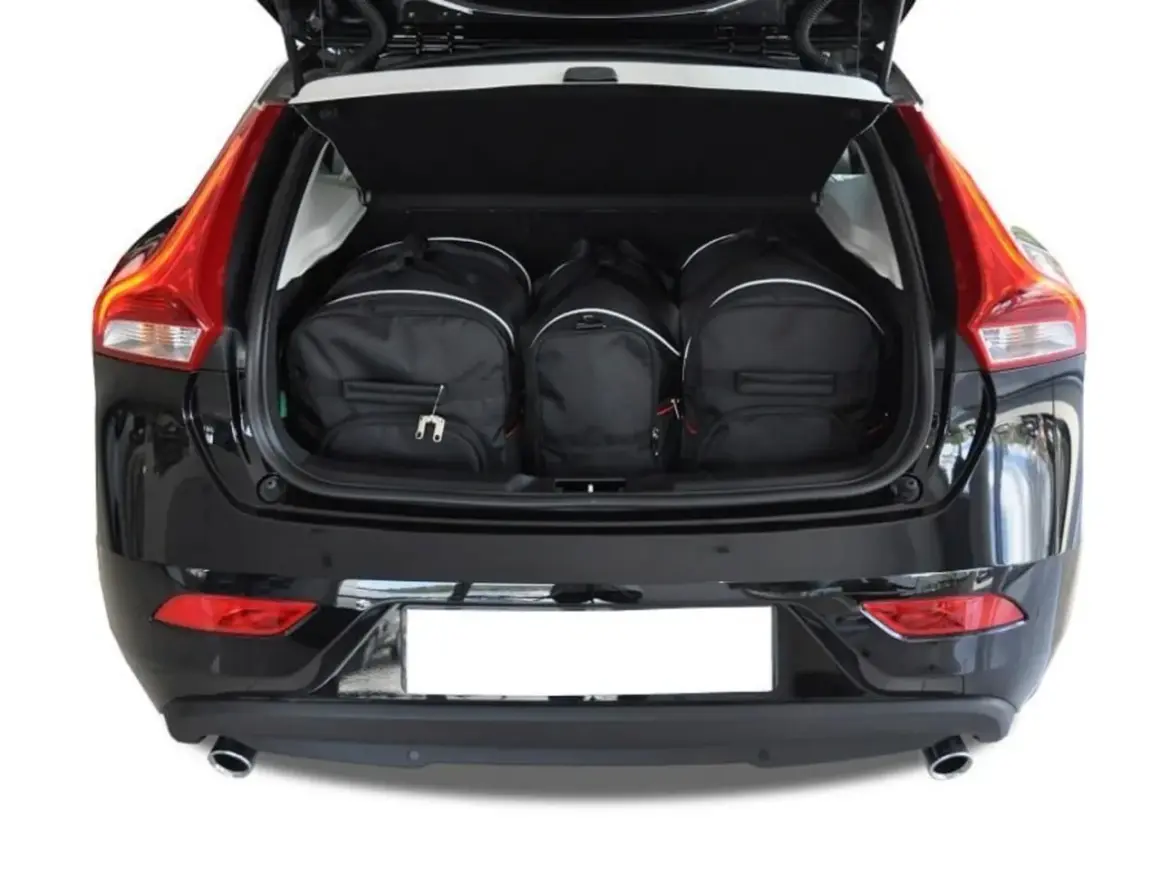 Tre svarta resväskor fyllda i volvo v40 bagageutrymme. Perfekt för en weekendresa!