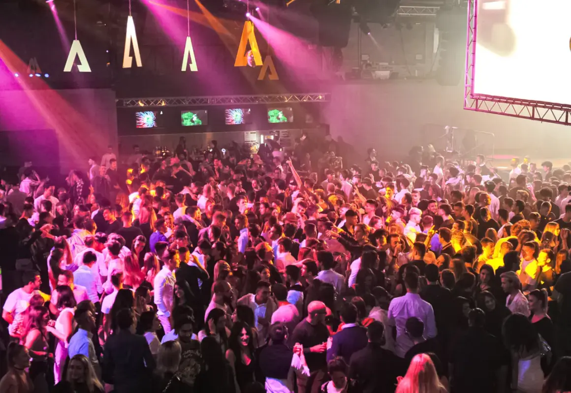 Folla in delirio all'Alcatraz Club Milano, luci rosa e arancioni illuminano la pista da ballo gremita di giovani.