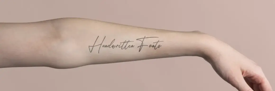 Ein langgezogenes Schrift Tattoo mit dem Schriftzug "Handwritten Fonts" auf einem Arm.