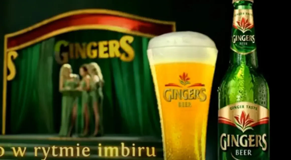Piwo Gingers: orzeźwiający smak imbiru w szklance i butelce, na scenie z tancerkami.