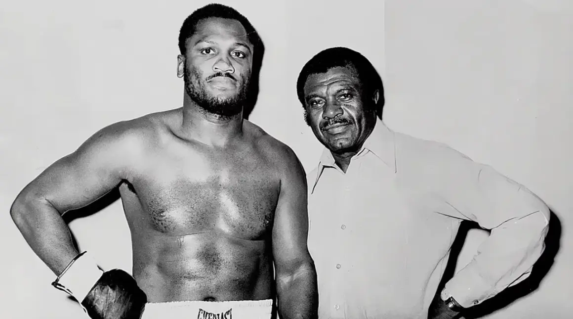 Joe Frazier, known for his impressive joe frazier height, stands with his trainer.