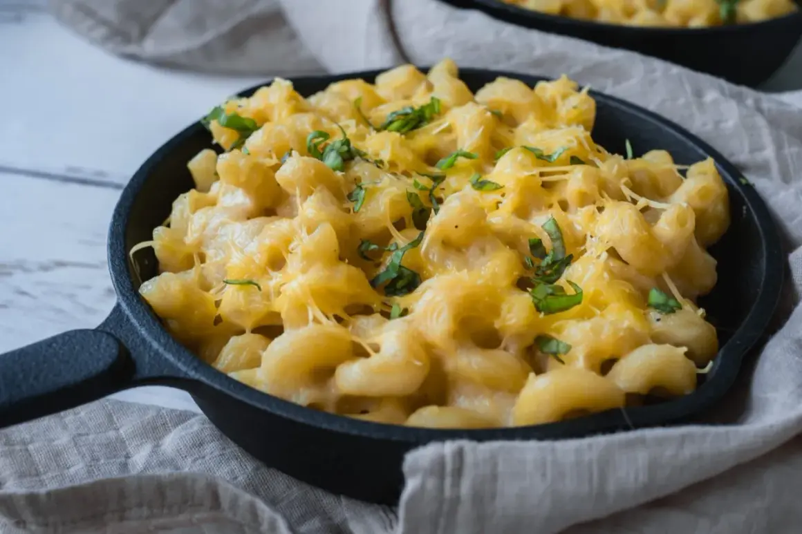 Krämig vegansk mac and cheese i gjutjärnspanna, toppad med färska örter. Enkel och god comfort food.