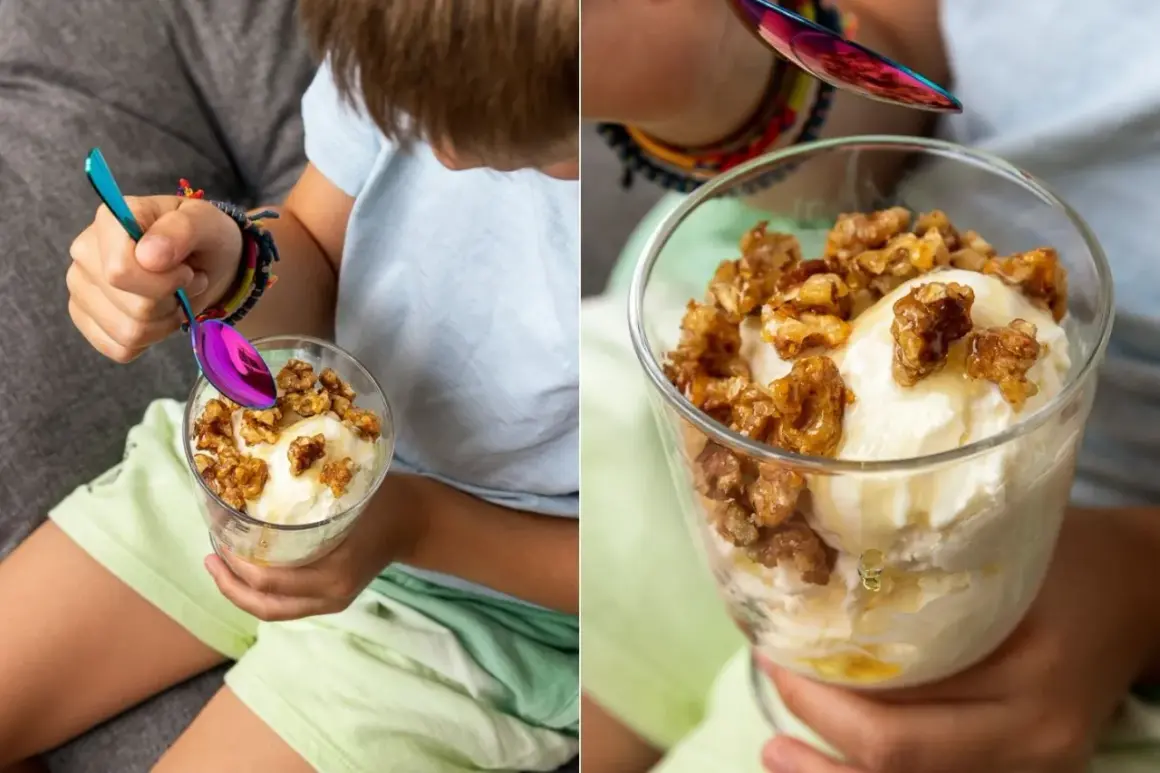Ein Kind genießt ein Glas cremiges griechischer joghurt eis ohne eismaschine, garniert mit Honig und Nüssen.