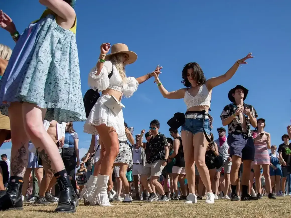 Giovani ballano felici in un boutique festival sotto il sole.