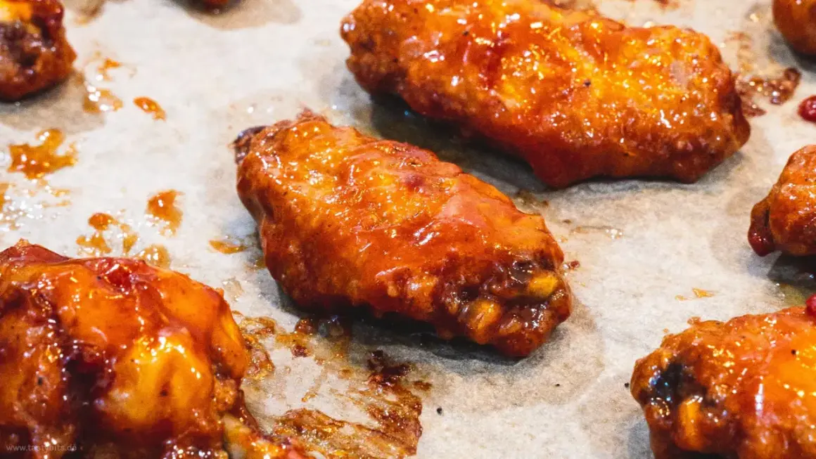 Saftige Hähnchenflügel in einer glänzenden, würzigen Marinade, bereit zum Genuss.