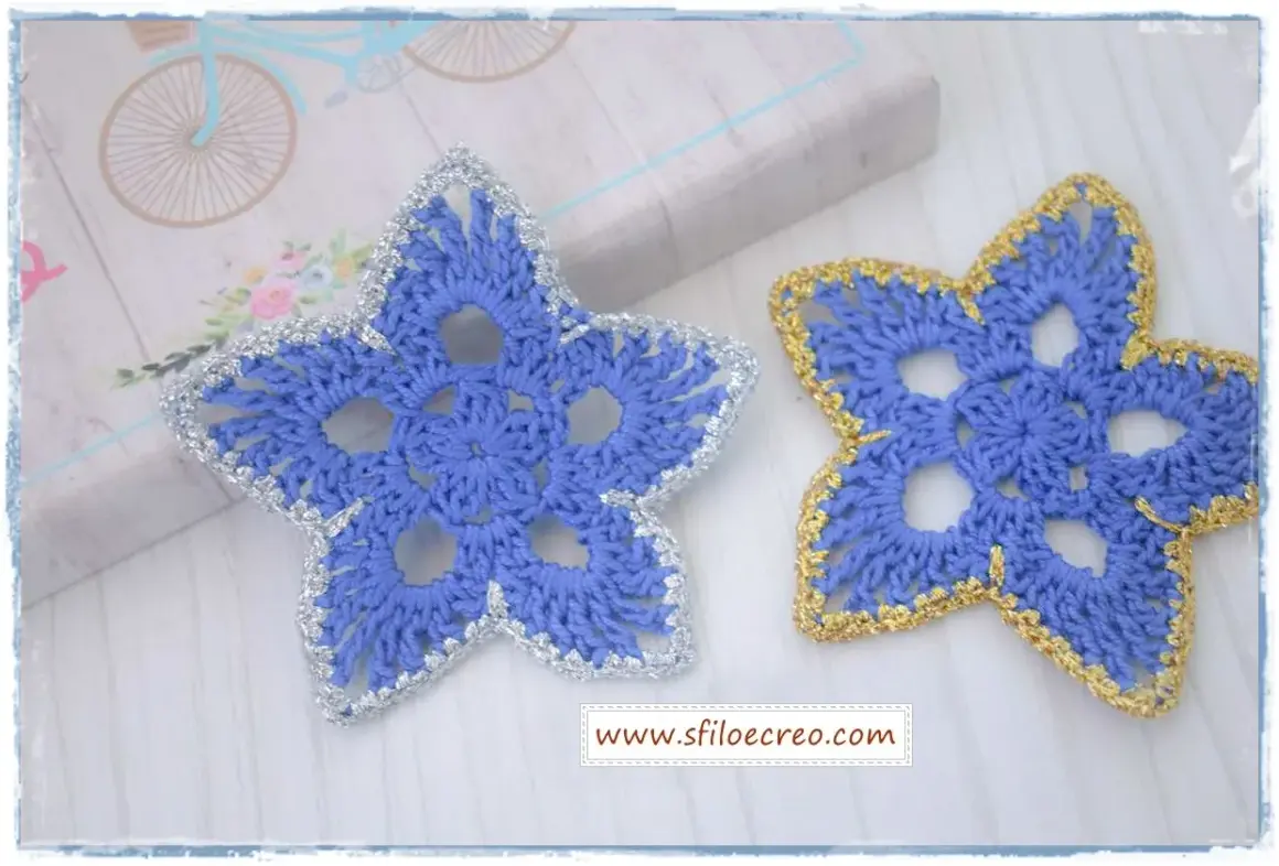 Stelline di Natale all'uncinetto schemi: due stelle azzurre con bordi argentati e dorati, perfette per decorare.