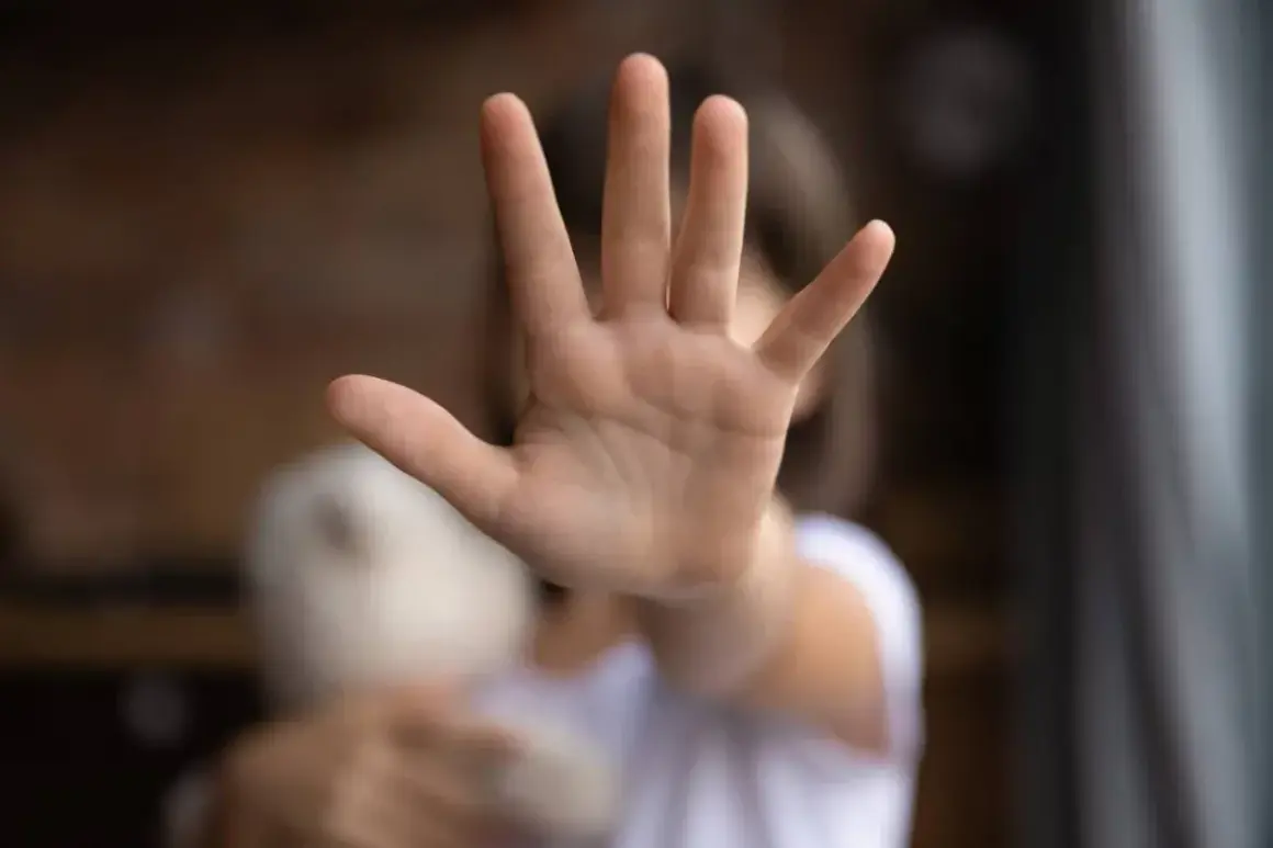 Dziecko z pluszakiem, ręka w geście "stop". Widać tu wyraźnie, jak proksemika może komunikować potrzebę przestrzeni.