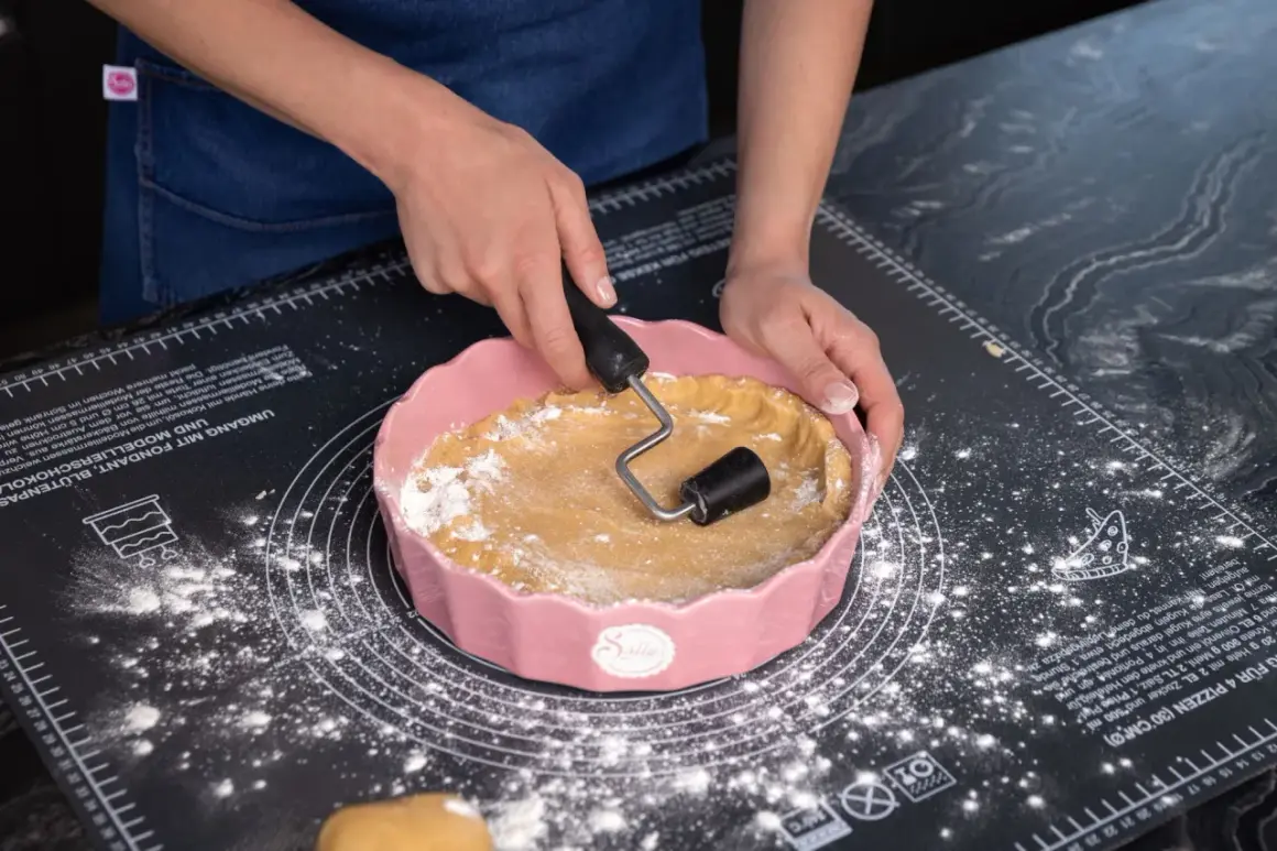 Sallys Kekse: Hände formen Teig in einer rosa Form auf einer Backmatte.