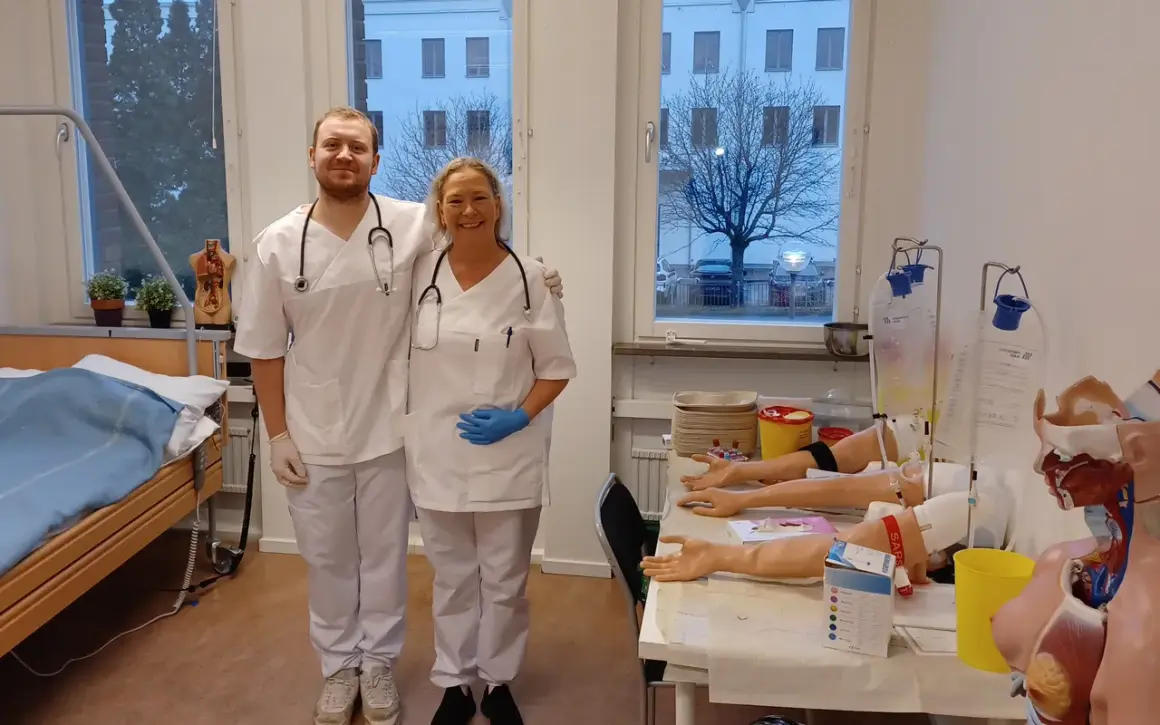 Två glada medarbetare från Medlearn AB i en övningssal med medicinsk utrustning.