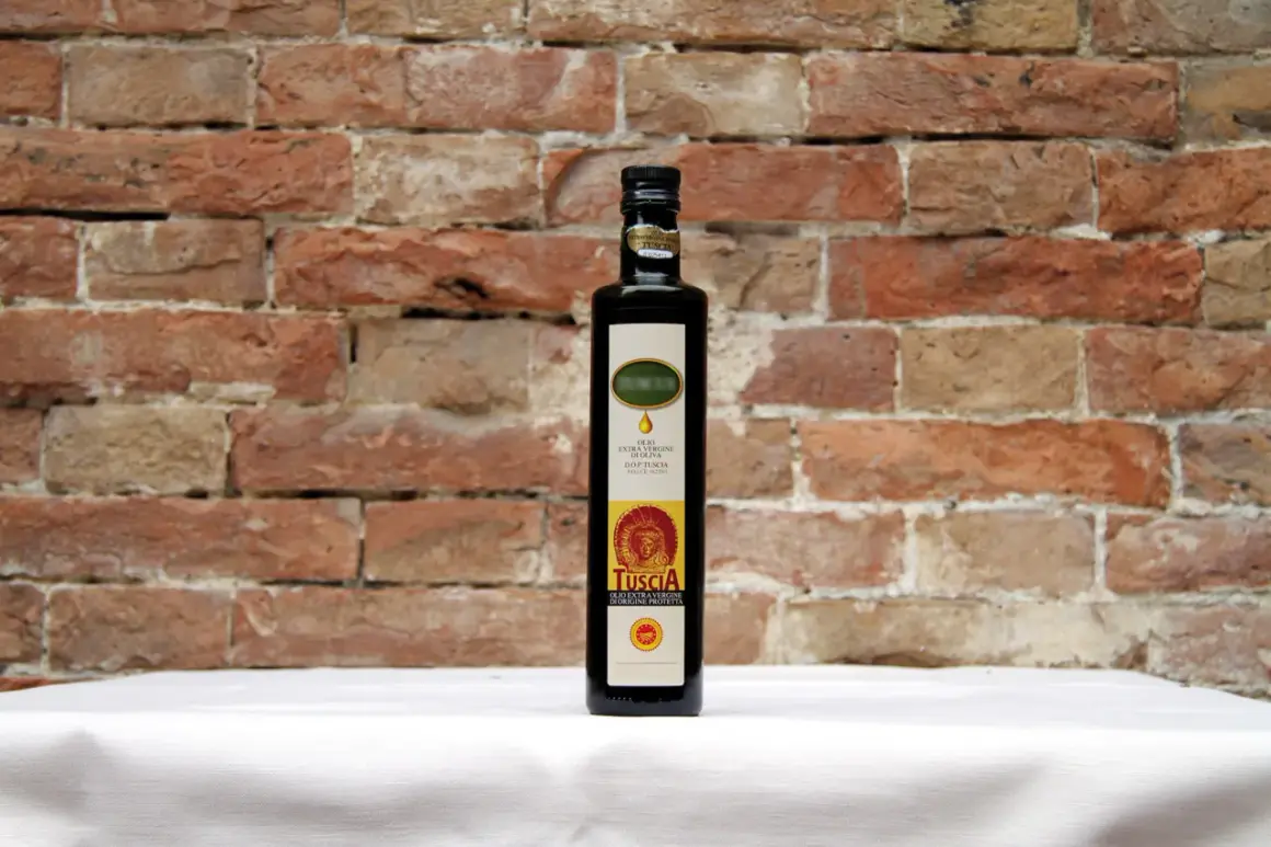 Bottiglia di olio extra vergine d'oliva D.O.P. Tuscia, il miglior olio della Tuscia, su sfondo di mattoni rossi.