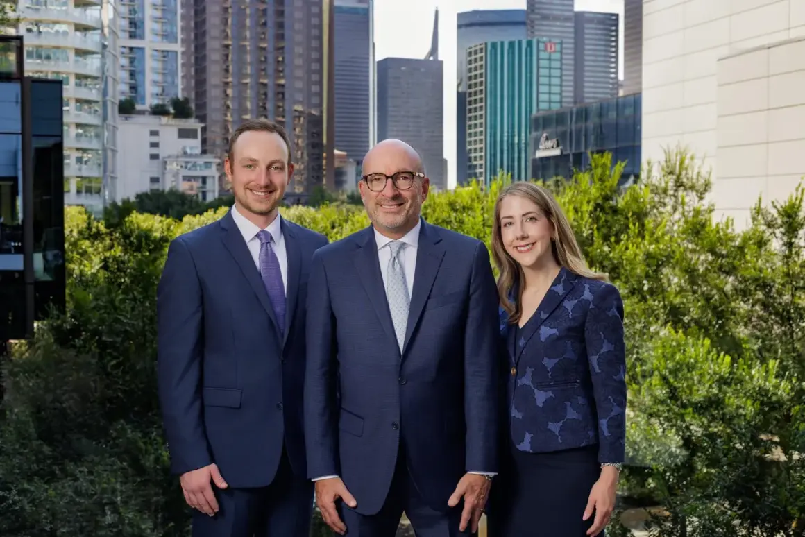 Alan Thomas Morgan Stanley: Three professionals in suits stand before a city skyline.