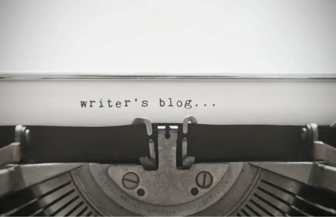 Maszyna do pisania z napisem "writer's blog...". Zastanawiasz się, jak napisać bloga po angielsku? Zacznij od tego!
