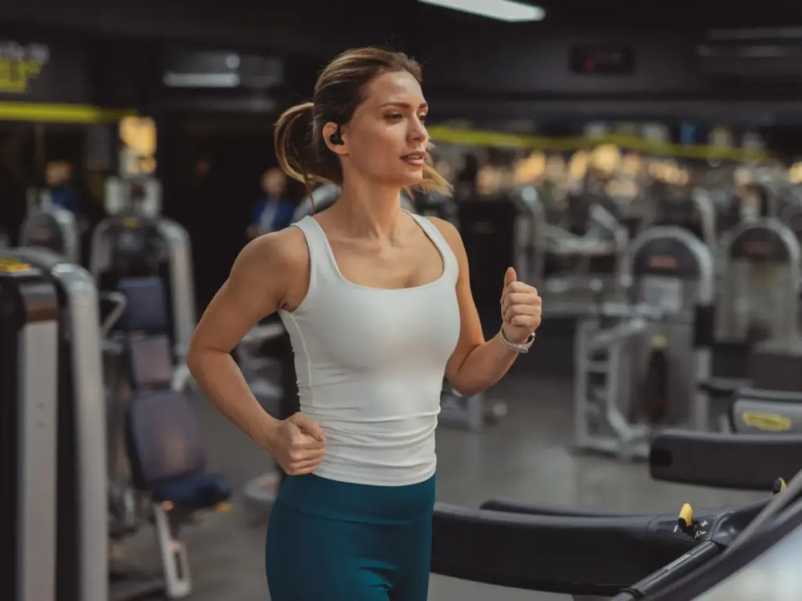 Frau läuft auf Laufband im Fitnessstudio. Sie fragt sich, wie oft Cardio in der Woche gut ist.